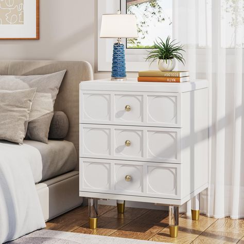 PRICES MAY VARY. 【3 Drawers for Your Storage】 - A set contains 1 white and gold nightstand. This tribesigns nightstand with 3 drawers can provide ample storage space for your bedside necessities, easily put in books, headphones, data cables and more. The smooth-gliding drawer allows you to easily access items, and the top is stable and can also be used to place desk lamps, tablets, and mobile phones. 【Elegant White Finish with Golden Decoration】 - Stylish white finish combined with luxurious gol Gold Nightstand Bedside Tables, Gold Bedside Table, White And Gold Nightstand, Acrylic Nightstand, Gold Nightstand, Tall Bedside Table, Storage Nightstand, Modern Chest Of Drawers, Small Chest Of Drawers