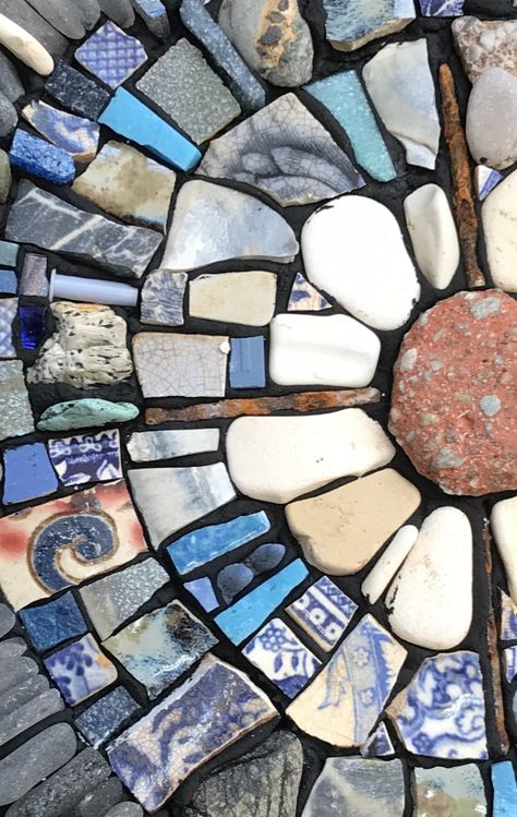 Detail of a mosaic made with found and recycled materials Mosaic Recycled Materials, Mosaic Art On Rocks, Sea Glass Mosaic Diy, Recycled Glass Mosaic, Mosaic Ideas Beginner Tile, Mosaic Rocks Design, Beach Pottery Art, Sea Pottery Mosaic, Rock Mosaic Art