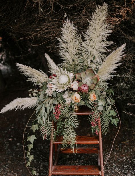 It’s taken over the pages of Green Wedding Shoes and our boho-wedding-lovin’ hearts: pampas grass! The greatest floral trend that’s already happening in weddings from California to Australia, this ornamental grass is native to South America and grows 10 to 13 feet high with a six-foot wing span. We’re spotting it in every aspect of... Bohemian Centerpieces, Rustic Bohemian Wedding, Blue Wedding Centerpieces, Bohemian Table, Grass Wedding, Rustic Bouquet, Wedding Table Flowers, White Wedding Flowers, Wedding Flower Decorations