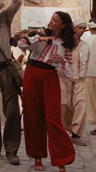 Fashion Meets Fandom: 3 Marion Ravenwood Outfits (Raiders of the Lost Ark) Marion Ravenwood, Raiders Of The Lost Ark, Effortless Chic Style, Elegant White Dress, Lost Ark, Forever Red, Loose Fitting Pants, Movie Fashion, Style Savvy