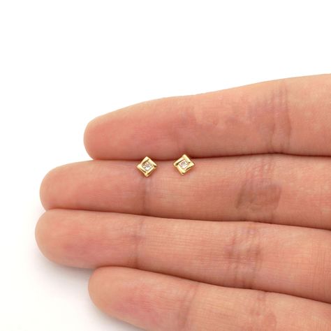 These cute and dainty square earrings are sparkled with dazzling round cut white zircon gemstones. The studs are safely secured with comfortable baby screwback closure. The earrings also come in 14k yellow and white gold variations. Product Specifics   Metal 14k Yellow Gold/ 14k White... Small Gold Stud Earrings, Studs For Kids Gold, Baby Earrings Gold Indian, Baby Earrings Gold, Earrings Gold Indian, Small Diamond Stud Earrings, Gold Earrings For Kids, Kids Gold Jewelry, Small Earrings Gold