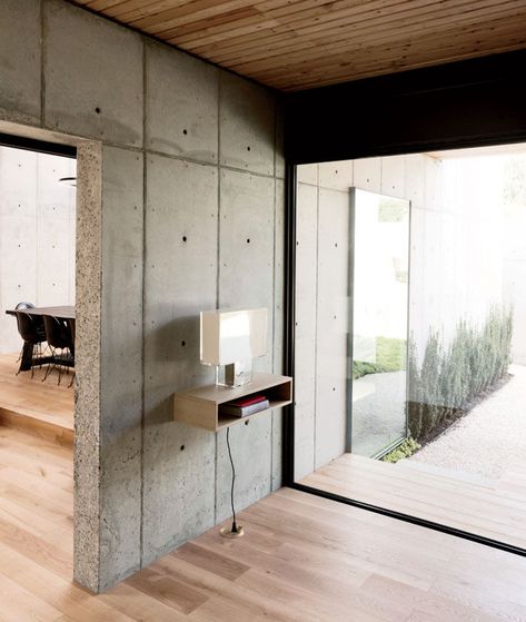 Modern Texas home with entryway with Tati lamp by Ferruccio Laviana and Kartell, white oak flooring, and concrete walls