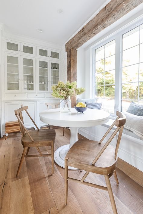 white cabinet glass builtin kitchen cabinets, rustic beams, round white table breakfast nook Round Breakfast Nook, Salons Cottage, Pool House Bathroom, Breakfast Nook Table, Table Breakfast, Nook Table, Lake House Kitchen, Cottage Living Rooms, Kitchen Nook