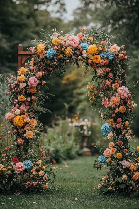 Colorful floral arch in a garden setting. Unleash your inner florist with wild and whimsical floral wedding ideas that will make your special day bloom like never before. Flower Arch Alternative, Wedding Mood Board Spring, Whimsical Fall Wedding Flowers, Backyard Wedding Spring, Flower Arch Wedding Outdoor, Ground Floral Arch, Wedding Flower Theme, Garden Arch Wedding, Garden Wedding Arch