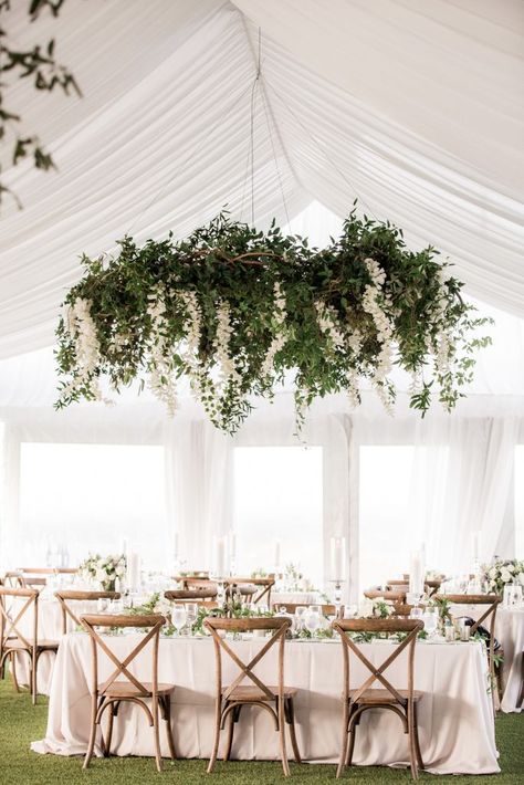 Hanging Wedding Floral Installations, Hanging Greenery Chandelier, Smilax Chandelier Wedding, White Flowers Hanging From Ceiling Wedding, Floral Hanging Wreath Flower Chandelier, Florals Hanging From Chandelier Wedding, Flowers Hanging From Chandelier Wedding, Enchanted Wedding Arch, Hanging Floral Chandelier Wedding