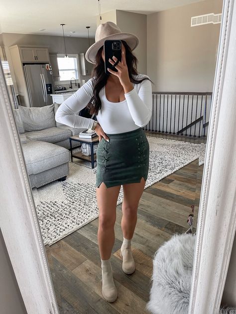 Mini Skirt And Boots Outfit Fall Fashion, Green Leather Skirt Outfit Fall, Body Suit Mini Skirt Outfit, Timberland Boots With Skirt, Skirt Christmas Party Outfit, Christmas Outfit Ideas For Women Green, Ankle Boots With Skirt Outfit, Bodysuit With Skirt Outfits, Green Skirt Fall Outfit