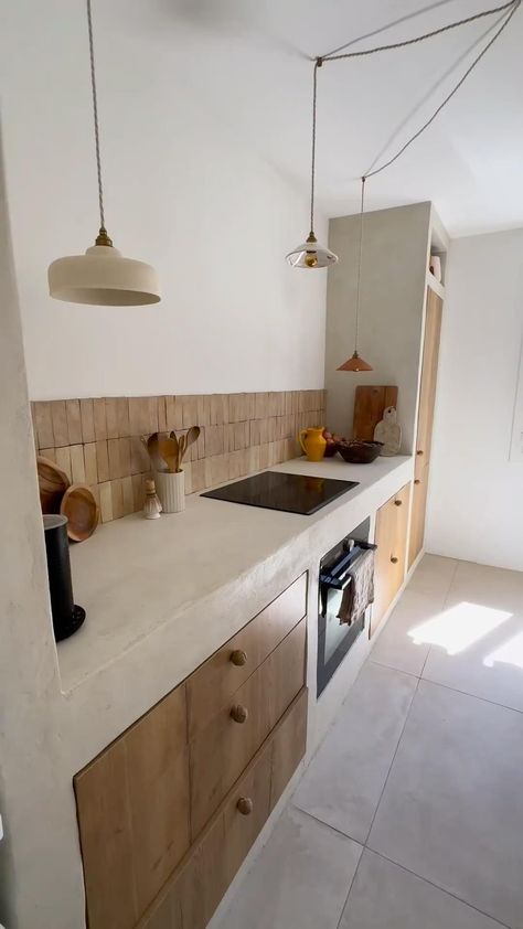 This Mediterranean-inspired kitchen blends rustic and contemporary elements with stucco countertops, wood cabinetry, and rattan pendant lights. An integrated bench with plush cushions adds comfort. Earthy tones and minimalist decor enhance the coastal vibe. SHOP similar products tagged. #MediterraneanKitchen #RusticCharm #StuccoCountertops #WoodCabinetry #RattanPendants #BenchSeating #MinimalistDecor #EarthyTones #CoastalVibe #HomeDecor #KitchenDesign #Benchseatingc#rattan #rattandecor Modern Mediterranean Kitchen, Mediterranean Style Kitchen, Mediterranean Kitchen Design, Rattan Pendant Lights, Countertops Wood, Mediterranean Interior, Mediterranean Kitchen, Rattan Pendant, Concrete Kitchen