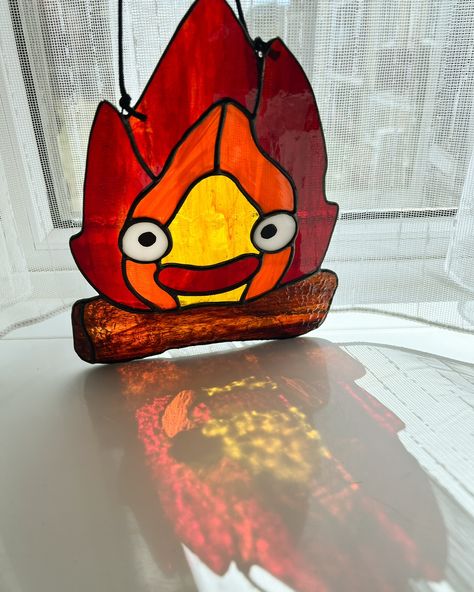 Calcifer is all done and sunning himself in my window - swipe for a surprise ➡️ #stainedglassartwork #calcifer🔥 #fanart🎨 #suncatcher Anime Stained Glass Art, Stained Glass Anime, Calcifer Ghibli, Stained Glass Suncatcher, Studio Ghibli Art, Glass Projects, Ghibli Art, Stained Glass Projects, Howls Moving Castle