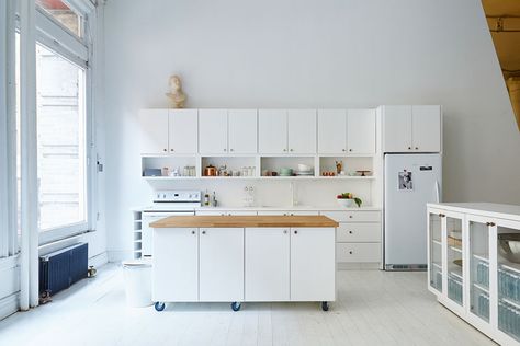 The wheels on the bottom of this movable white kitchen island with a wood countertop, lets people move it around so they can prep things closer to the rest of the counter or move it out of the way entirely when they need more floor space. Moveable Kitchen Island, Baby Cupboard, Hobby Corner, Sustainable Kitchen Design, Movable Table, Island On Wheels, Portable Kitchen Island, Mobile Kitchen Island, Sakara Life