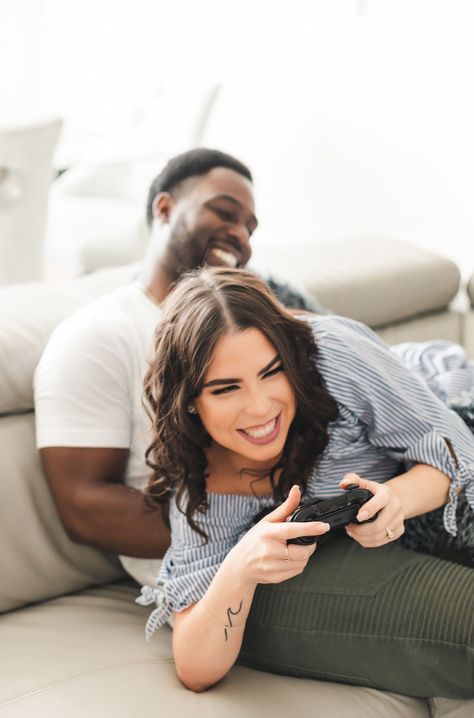 Groom to be playing video games with Bride to be fun and candid at home engagement session. Kari wearing blue romper and Ralph wearing white tshirt and army green pants. Photo by Sandra Monaco Photography  #AtHomeEngagementSession #HomeEngagementSession #posesforgamers #videogamelovers #CasualEngagementSession #EngagementPosing #PosingCouples #PosingInspiration #CandidPosing #AtHomeEngagementShoot Gaming Couple Photoshoot, Gaming Engagement Photos, Video Game Engagement Photos, Gamer Engagement Photos, Gamer Couple Tattoos, Video Game Photoshoot, Monaco Photography, Couple Engagement Shoot, Couple Tattoos Ideas