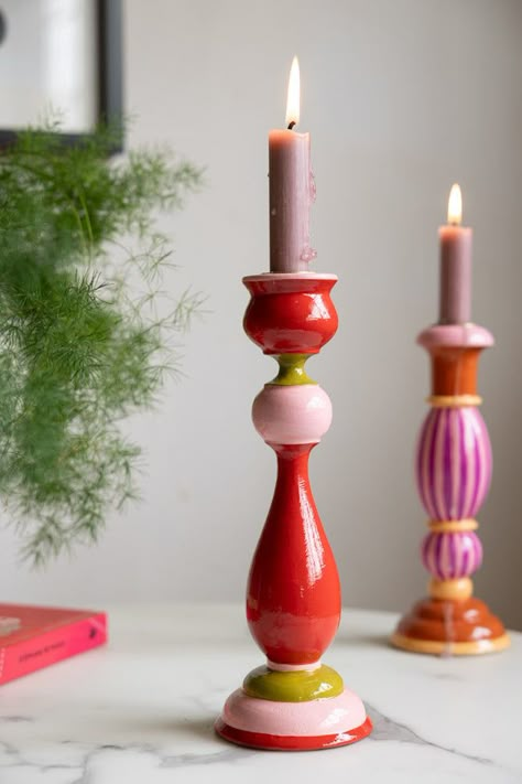 There’s nothing like candlelight to create the perfect mood, whether you’re hosting a romantic dinner a deux or cooking a cosy meal for friends or family. This beautiful candlestick holder is fabulously rustic in look and feel, crafted from ethically-sourced wood and hand-painted in bold, bright colours that add a pop of personality to your table or sideboard. We love to style this as pair, or mix and match with other candlestick holders from the range to create an eye-catching focal point to the room. Experiment with your favourite colours and go as wild as you dare – your home, your rules!  - Colourful Candlestick Holder in Red & Pink - Material: Wood- Measures: H26cm x Base 9cm. Opening for candle 2cm- Never leave a burning candle unattended Room Objects Decor, Pop Of Colour Decor, Painted Candlestick Holders, Clay Candlestick Holders, Clay Candle Stick Holders, Red And Pink Decor, Painted Candle Stick Holders, Bright Room Decor, Painted Wooden Candle Holders