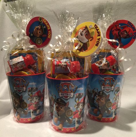 Paw Patrol Party Favors  • hard plastic cups  ($.69@Christmas Tree Shops)  • Crayola crayons (Amazon for about $.70/ea.) • Paw Patrol mini activity book (Party City for $.10/ea) • Mini play-doh (10 pack for $4.99 @ Christmas Tree Shops) • Mini Paw Patrol bubbles (Party City for $.15/ea)  All wrapped in cellophane with a little white curling ribbon with a "lollipop" tag printed from NickJr. for free   Great for ages 2-7 or so. Paw Patrol Party Cups, Paw Patrol Candy Table Ideas, Paw Patrol Party Centerpieces Diy, Paw Patrol Favors Ideas, Paw Patrol Party Bags Ideas, Paw Patrol Favor Bags, Paw Patrol Party Table Ideas, Paw Patrol Goodie Bags Ideas, Paw Patrol Birthday Favors