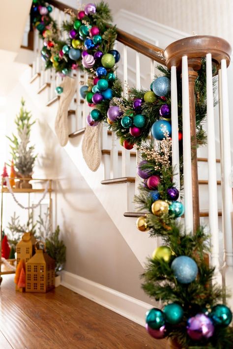 Colorful Christmas Staircase Decorating Ideas | HGTV Multi Colored Christmas Tree Decorations, Holiball Decorating Ideas, Stair Railing Christmas Decorating Ideas, Christmas Railing Decor Indoor, Colorful Christmas Garland, Christmas Railing, Staircase Christmas Decor Railings, Jewel Tone Christmas, Christmas Garland Ideas