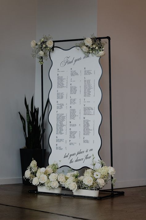 Modern black and white seating chart wtih curvy edge and white flowers baby's breath industrial wedding at Glass House Seating Chart Wedding Black And White, Black And White Wedding Seating Chart, Black Seating Chart Wedding, Unique Seating Chart Ideas, Black Wedding Seating Chart, Black And White Seating Chart, Seating Chart Ideas Wedding, Diy Seating Chart Wedding, White Seating Chart