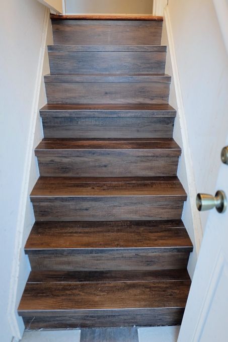 A DIY install of peel and stick wood-look vinyl flooring on our back stair. Faux Wood Tiles, Cellar Ideas, درج السلم, Stair Makeover, Peel And Stick Wood, Stairs Makeover, Staircase Makeover, Tile Stairs, Basement Stairs