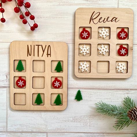 Personalized engraved Wooden Tic Tac Toe with festive acrylic pieces for a special touch to the Christmas gift.  Surprise kids with this or use them as a Christmas class gift. These are made from Birch Plywood. The size of the game board is 6 in x 5 in. Comes with an organza bag for storage ready to be gifted. You can choose the shapes of game pieces from the drop-down menu. Includes a total of 10 game pieces. Game pieces are laser cut from high-quality acrylic. Game pieces are approximately 1X1 Laser Cut Christmas Ideas, Christmas Tic Tac Toe, Christmas Countdown Diy, Wood Laser Ideas, Glowforge Ideas, Laser Cut Box, Wood Projects For Kids, Wooden Christmas Crafts, Laser Ideas