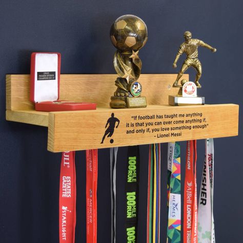 Our personalised medal hanging shelf is a great gift for the sports enthusiast which you can hang and display your medals and trophies.Sports symbols available: 1. Football 2. Rugby 3. Tennis 4. Swimming 5. Cycling 6. Running 7. Hockey 8. Gymnastics/Ballet 9. GolfAre all of your medals and trophies currently tucked away in a cupboard somewhere? Well this is a perfect way to display all of your achievements in one place. Proudly show off your running, football, swimming, ballet, hockey and ... Medals And Trophies, Hook Shelf, Trophy Shelf, Medal Rack, Trophy Display, Kids Awards, Running Medals, Trophies And Medals, Medal Holders