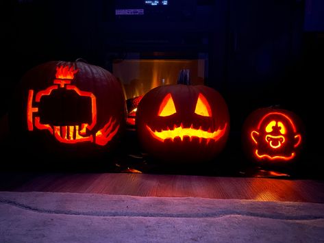 Three carved pumpkins. One is carved as a check engine light, one is a face with triangle eyes and gentle teeth in a grin and the last is a baby ghost with a pacifier. Check Engine Light Pumpkin, Cute Pumpkin Carving, Pumpkin Lights, Cute Pumpkin, Halloween Outdoor Decorations, Jack O Lantern, Pumpkin Carving, Halloween Decorations, Carving