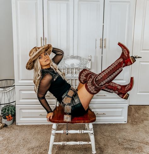 Slaying Outlaw in All Black ♠️      Top: this mesh sleeve top is perfect for a night out with a sweetheart carved out neckline.      Leather Shorts: these are the perfect cowgirl chic look and they pair very well with a concho belt!      Hat: a western burned hat with a red velvet to complement your boots!       Belt: a concho belt that’s shaped square to complement the space between the top and leather pants.      Accessories:    Navajo pearls. The sterling goes with black so well and gives ... Western Concho Belt Outfit, Concho Belt Outfit, Western Belts Outfit, Black Western Outfit, Black Cowgirl Outfit, Leather Shorts Outfit, Skort Outfit, Black Cowgirl, Pants Accessories