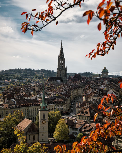 A breathtaking autumn view of Bern with the iconic Swiss Federal Palace (Bundeshaus) and the Bern Minster towering above the city’s historic rooftops. Framed by vibrant fall leaves, the scene captures the harmonious blend of nature and architecture in Switzerland’s capital. The warm colors of the season highlight the timeless beauty of Bern’s Old Town, offering a perfect snapshot of the city’s rich heritage and peaceful ambiance. 📸 instagram.com/nicolereinhard_photography/ Nature And Architecture, Bern Switzerland, Bern, Fall Leaves, Girl Face, Warm Colors, Old Town, Timeless Beauty, Autumn Leaves