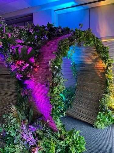 Bamboo Theme Party, Jungle Boogie Party, Festival Theme Decorations, Jungle Booth Design, Jungle Entrance Decor, Neon Outdoor Party, Tunnel Decoration Entrance, Neon Jungle Party Decorations, Jungle Event Decor