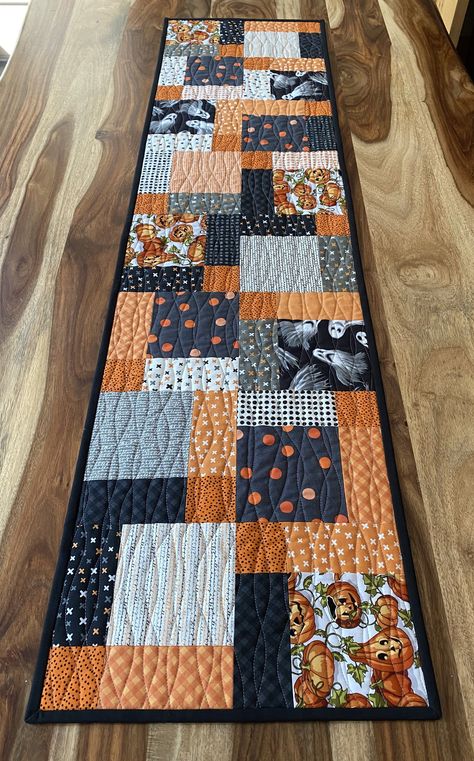 Two occasions in one! One side of this table runner is made from modern Halloween fabrics with traditional colours of black and orange, as well as pumpkins and ghosts. The reverse side is modern black and white fabric depicting deer. The two sides are separated by a purposeful blue band of fabric that looks like stars in the sky. It would suit winter or Christmas décor, but could be used year round if this is your colour scheme. It is quilted together with unique wavy line quilting. Simple Quilt Table Runners, Quilted Halloween Table Runners, Modern Quilted Table Runner, Halloween Table Runners Quilted, Halloween Quilts Ideas, Quilt Table Runners, Winter Table Runner, Quilt Runners, Quilted Table Runners Christmas