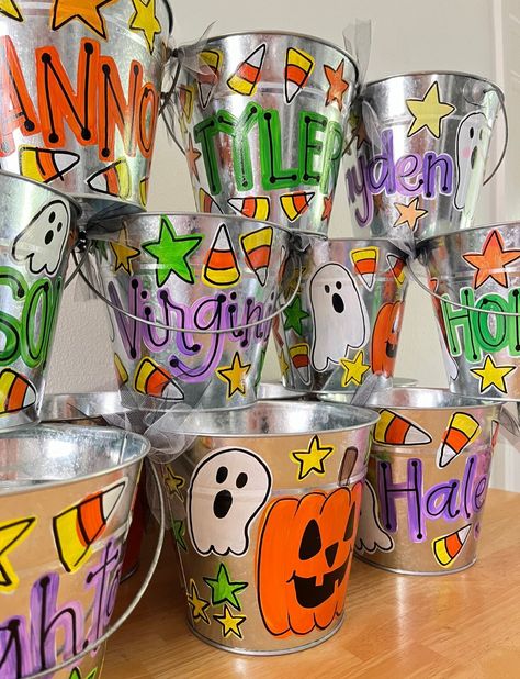 These hand painted, personalized Halloween buckets are perfect for gift giving, decorations, or trick or treating. Painted to order, sealed for protection, and shipped to you for spooky season!  Approximately 7x6" Painted Trick Or Treat Bags, Painted Trick Or Treat Buckets, Diy Halloween Bucket, Diy Halloween Buckets For Kids, Hand Painted Items To Sell, Diy Halloween Baskets For Kids, Hand Painted Crafts, Painted Halloween Buckets, Painted Buckets Ideas