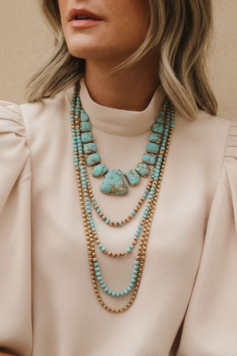 Elevate your look with this stunning layered turquoise necklace, a must-have for any fashion-forward wardrobe. The combination of earthy turquoise stones and golden accents creates a unique and trendy accessory perfect for adding a pop of color to any outfit. Whether you're dressing up or down, this jewelry essential will make a bold fashion statement. Turquoise Jewelry Styling, Turquoise Necklace Outfit, Turquoise Jewelry Outfit, Necklace Outfit, Bold Earrings, Brown Outfit, Jewelry Essentials, Turquoise Stones, Unique Materials