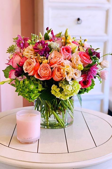 A breathtaking floral arrangement that captures the essence of a serene garden. Delicate peach and pink roses intertwine with elegant purple hellebores, lush green hydrangeas, and soft pink lisianthus, creating a harmonious and romantic composition. The arrangement is presented in a clear cylindrical glass vase, allowing the vibrant colors and intricate textures of the flowers to be showcased in their full glory. This exquisite piece is perfect for gifting or adding a touch of elegance and sophi Fall Floral Arrangements Centerpiece, Flower Arrangements Roses, Romantic Flower Arrangements, Luxury Floral Arrangements, Floral Arrangements Centerpieces, Pink Lisianthus, Garden Tattoos, Serene Garden, Get Well Flowers