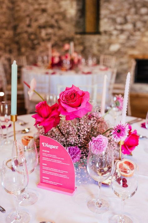 Neon pink vibrant floral table centrepiece of roses and gypsophila with twisted candles and pomegranate fruit decor Floral Theme Table Decor, Pink Table Flowers Wedding, Fushia Table Setting, Modern Pink Tablescape, Pink Flower Table Decorations, All Pink Floral Centerpieces, Bright Pink Wedding Centerpieces, Wedding Table Decorations Round Tables Pink, Pink Table Flowers