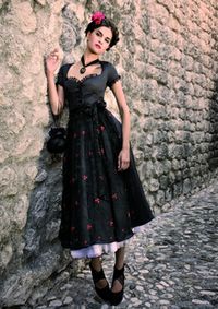 There's a beguiling Spanish vibe to this endlessly elegant black dirndl ensemble Drindl Dress Modern, Black Dirndl Dress, Dirndl Dress Traditional, Black Folk Dress With Embroidered Hem, Metalhead Fashion, Black Folk Dress With Floral Embroidery, German Dress Dirndl, German Folk, German Dress