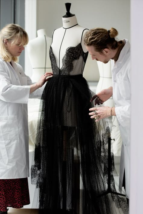 In the Dior Ateliers, the House’s petites mains can be seen putting the finishing touches on an ethereal black tulle gown from the recently unveiled Dior Fall 2022 show by Maria Grazia Chiuri in Seoul, offset with ruffles and delicate lace trims. One of 10 looks specially designed for the event, the unapologetically feminine dress served as a counterpoint to the show’s uniform-inspired looks. Black Tulle Gown, Ewha Womans University, Dior Archive, Dior Fall 2022, Fashion Construction, Neo Romantic, Dior Atelier, Draping Techniques, Fashion Atelier