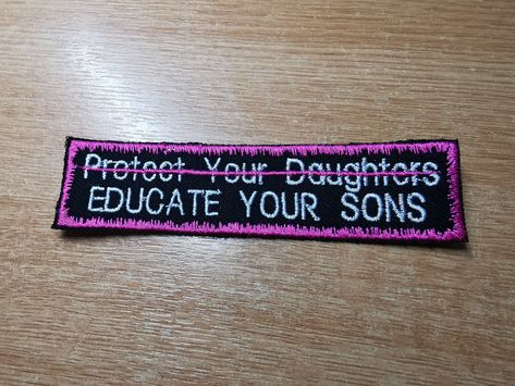 "Embroidered Patch with \"Educate your Sons\" beneath the crossed out with a scrawled flamingo pink line, \"protect your daughters\". Surrounded by the same flamingo pink, in a fuzzy snow border, this patch speaks out against the misogynistic societal belief that women are solely responsible for their own safety, and that the blame does not lie at the feet of the patriarchy.  Dimensions: 12 x 3cm The original red version is available in store! This is just a new colour variation. Feel free to re Protect Your Daughter Educate Your Son, Feminist Patches Punk, Leftist Patches, Feminist Protest, Crust Pants, Feminist Patch, Battle Vest, Punk Fashion Diy, Punk Jacket