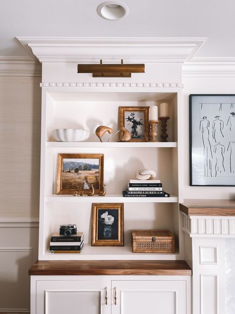 The shelves aren’t perfect—for starters, I obviously need to move the mini brass frame on the middle shelf and space out the others 🙈—but I love my little work in progress! Styled Bookshelves Fireplace, Traditional Shelf Styling, Modern Traditional Shelf Decor, Styling Tall Shelves, French Shelf Styling, Traditional Shelf Decor, Traditional Bookshelf Styling, Entertainment Shelf Decor, How To Display Nick Nacks