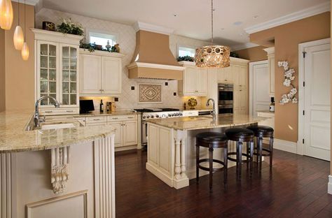 Kitchen with antique white cabinets and dark engineered mahogany floors White Kitchen Dark Floors, Floor Kitchen Living Room, Mahogany Floors, Antique Kitchen Cabinet, Dark Kitchen Floors, Coastal Inspired Kitchens, Dark Island, Antique White Kitchen Cabinets, Antique White Cabinets