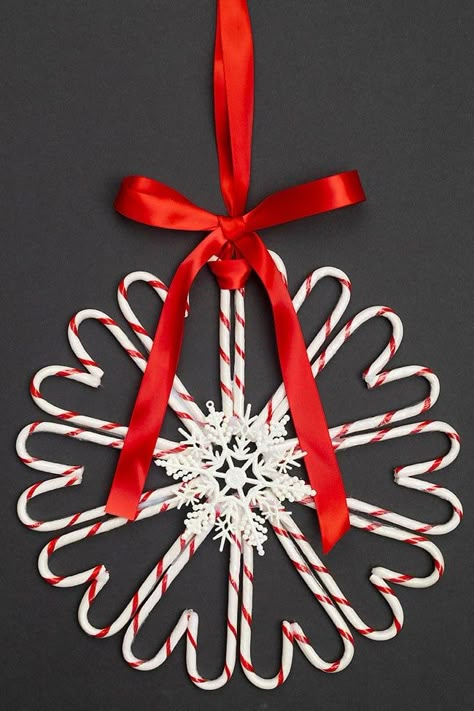 This candy cane wreath is SO CUTE and festive! It's so simple to make your own DIY Christmas wreath using candy canes from the dollar store. Both kids and adults will have fun making this easy Christmas craft that looks so pretty hanging on any door! Candy Cane Reef, Candy Christmas Wreaths Diy, Candy Cane Wreaths Diy How To Make, Plastic Candy Cane Crafts, Candy Cane Party Decorations, Clothespin Wreath Diy Christmas, Easy Wreaths To Make Christmas, Candy Cane Crafts Diy, Candy Cane Wreaths Diy