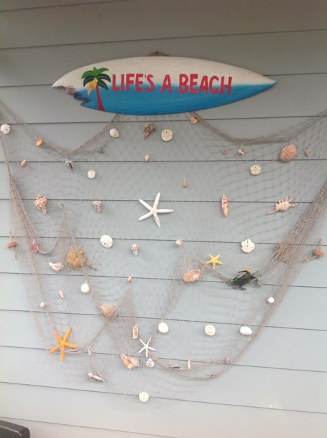 This is a fishing net I put together hanging my shells using Christmas ornament hooks. Fishnet Wall Decor Ideas, Fishing Net Decor, Homestay Ideas, Fishing Net Wall Decor, Pool Area Decorating Ideas, Fish Net Decor, Seashell Display, Seashell Art Diy, Beach Theme Living Room