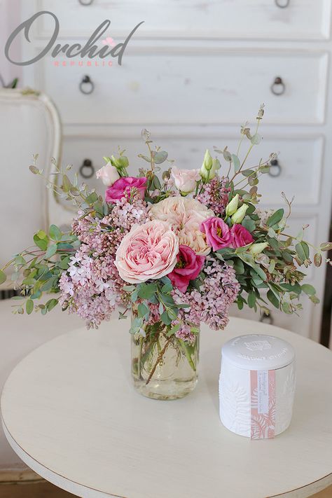 Simple yet stunning, this loose flower arrangement features fresh spring blooms, such as peonies in delicate swirls of blush, hot pink spray roses, clouds of lilacs, and buds of lisianthus bursting amidst a thicket of lush foliage. It is presented in a charming glass jar. Bride Bouquet Pink, Simple Floral Centerpieces, Pink Spray Roses, Pink Flower Arrangements, Early Spring Flowers, Spring Floral Arrangements, Blush Wedding Flowers, Bridal Shower Centerpieces, Flowers Bouquet Gift