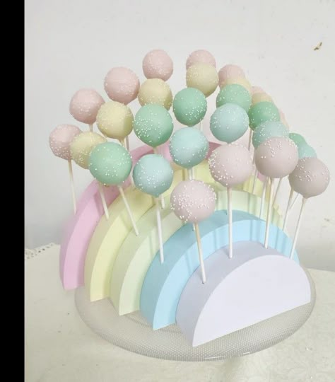 Cakepops colocados em estrutura de esferovite Cake Pops Pastel Colors, Rainbow Birthday Dessert Table, Pastel Rainbow Bridal Shower Ideas, Pastel First Birthday Cookies, Pastel Rainbow Cake Pops, Care Bear Cake Pops, Pastel Rainbow Centerpieces, Pastel Rainbow Birthday Theme, Pastel Rainbow Dessert Table