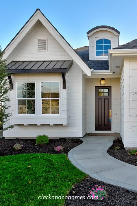 Classic farmhouse style for this home comes from contrast with the metal awning and painted front door as well as small details like the arched dormer and window bay. #modernfarmhouse #farmhousestyle #metalawning #blackdoor #whitepaint Modern Farmhouse Awnings Over Windows, Dormer Over Front Door, Modern Awnings For Windows, Bay Window Awnings Exterior, Roof Over Window Curb Appeal, Modern Bay Window Ideas Exterior, Metal Awning Over Window, Homes With Bay Windows Exterior, Bay Window Front Of House