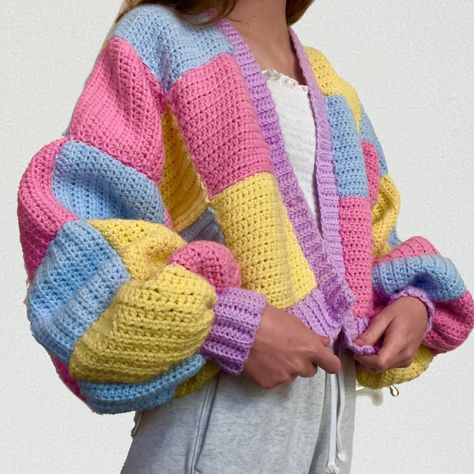 Harry Styles-inspired cardigan oversized crochet sweater. Made from high-quality yarn throughout the entire sweater. Completely handmade, this sweater has 3 different pastel colors: pink, blue, and yellow, and a purple lining for the sweater and arm cuffs. This sweater is absolutely perfect as a gift for any Harry Styles lover! Crochet Cardigan Color Ideas, Crochet Sweater Trendy, Square Crochet Sweater, Crochet Sweater Squares, Colorful Crochet Cardigan, Pastel Crochet Ideas, Crochet Colorful Cardigan, Multicolor Crochet, Harry Styles Sweater Crochet Pattern