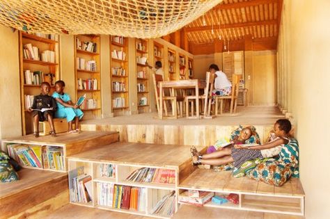 The Library of Muyinga is a light-filled educational facility for deaf children in Burundi that is built from locally-sourced compressed earth. Vernacular architectural practices were reinterpreted to meet modern requirements for educational spaces, which includes cozy sitting arrangements and huge hammocks where kids can read their favorite books. Sustainable Schools, Sitting Arrangement, Rammed Earth Wall, Childrens Library, Library Architecture, Kids Library, Book Cafe, Green Architecture, Library Design