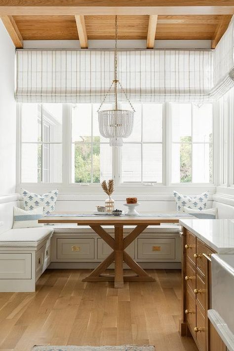 Hung from a brown wood plank ceiling over a square trestle dining table, a white beaded chandelier lights a breakfast nook finished with a built-in u-shaped dining bench. White Beaded Chandelier, Latest Kate, Designers Portfolio, Neutral Interior Design, Wood Plank Ceiling, Kate Marker Interiors, Blogger Home, Transitional Dining Room, Plank Ceiling