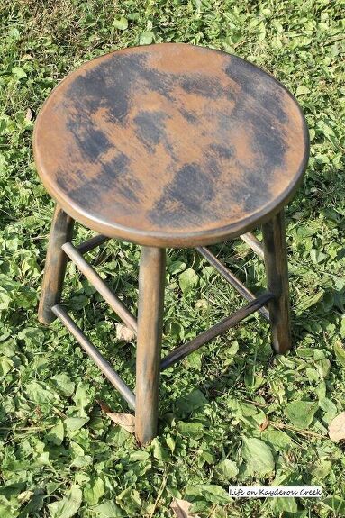 Most of the fun in decorating for me comes from trying to find interesting pieces that give our home character. I guess that’s why I love vintage and antique pieces so much because they are usually worn in such a perfect way and have a great patina.One of the things that I’m drawn to is the look of these old fashioned farmhouse milking stools. They are great for adding height to your vignettes and character to your space. I decided to make one out of a plain wooden kitchen stool. Her… Old Fashioned Farmhouse, Diy Wallpaper Headboard, Wooden Kitchen Stools, Home Character, Wine Picnic Table, Bar Stool Makeover, Farmhouse Style Curtains, Green Spray Paint, Modern Baskets