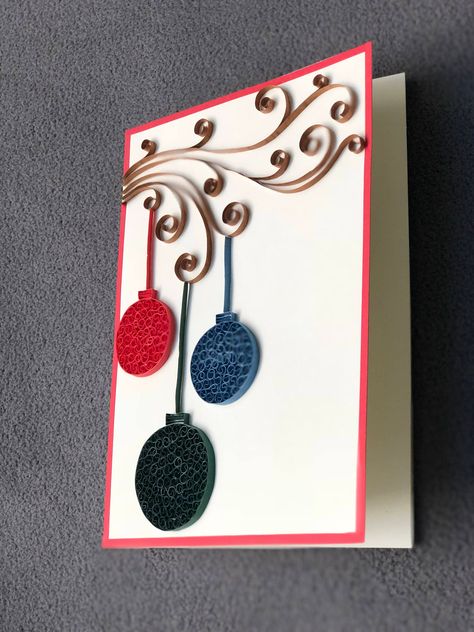 "Handmade greeting card with unique quilling technique, intricate design and great craftsmanship. Occasion- Christmas, Happy Holidays, New Year, Thank you card. Product information- This beautiful greeting card is made with quilling technique. I decorated this card various sizes of Christmas decoration in red, blue and green colors, hanging from a branch. The materials used for the card are card stock, and 3mm. quilling strips. The size is 5\"x 7\". Every card comes with a matching cream envelop Quilling Christmas Cards Xmas, Christmas Quilling Ideas Greeting Card, Christmas Card Quilling, Simple Quilling, New Year Greeting Card Handmade, Quilling Cards Ideas Simple, Paper Quilling Christmas, Christmas Paper Quilling, Quilled Christmas Cards