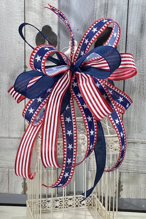 "Independence Day Bow made with 1.5 Canvas Ribbon in blue and stripes with stars.  Red and white satin ribbon.  Can be added to a Wreath, Lantern, Bird Cage, Railing, Pole, tree topper or any where you need to brighten with patriotism. Approximately 14\" W x 19\" L Multiples of this Bow can be made and Different sizes. If you like would like a different size message me for pricing. *Bird Cage not included. SHIPPING INFO: All items listed in the shop are ready to ship unless it is not stated so in the listing. They will be shipped within 1-3 business days of payment received unless otherwise stated. Shipping carriers typically used are USPS, UPS and Fedex. The wreaths are big and require special packaging. Some of sizes of the boxes are considered oversized by the shipping carriers hence th Ribbon Organization, 4th July Crafts, 4th Of July Decor, Patriotic Bows, Fourth Of July Decor, July Decor, Patriotic Crafts, Blue Wreath, 4th Of July Decorations