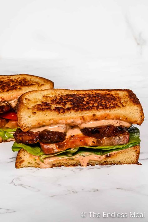 This pork belly sandwich is out-of-this-world delicious! It's crispy strips of pork belly, spicy chipotle mayo, marinated tomatoes, and tender lettuce layered between slices of toasted sourdough bread. It's a simple sandwich with big flavors and it's ready in an hour! #theendlessmeal #sandwhich #porkbelly #porkbellysandwhich #pork #lunch Pork Tenderloin Pulled Pork, Tenderloin Pulled Pork, Jam Grilled Cheese, Cheesesteak Recipes, Pork Lunch, Pork Belly Sandwich, Sandwich Picnic, Pork Chop Sandwiches, Pork Belly Strips