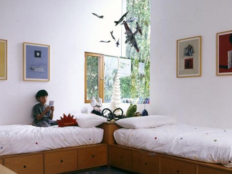 Instead of the standard arrangement of beds on opposite walls, try putting a large nightstand in the corner of the room with the head of the beds placed perpendicular to each other. Warning: It may encourage late-night chats, but at least they're getting along, right? Design by David Hertz. Twin Boys Bedroom, Shared Boys Rooms, Kids Rooms Shared, Boys Shared Bedroom, Small Guest Bedroom, Kids Shared Bedroom, Small Kids Room, Shared Kids Room, Boys Room Design