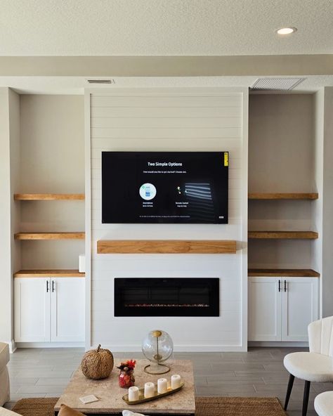 Elevate your living space with our custom entertainment center designs! 🎨✨ This latest project showcases a beautiful blend of modern aesthetics and functional design, featuring built-in shelving, a sleek electric fireplace, and a perfectly mounted TV. The natural wood accents add warmth and contrast beautifully against the shiplap backdrop, creating a cozy and inviting focal point in this home. Whether you’re looking to upgrade your living room or create a stunning feature wall, we’ve got yo... Shiplap With Built Ins, Custom Built In Entertainment Center With Fireplace, Small Built In Entertainment Center, Electric Fireplace Built Ins With Tv, Wood Built Ins Living Room, Built In Entertainment Center Fireplace, Shiplap Backdrop, Custom Entertainment Center, Natural Wood Accents