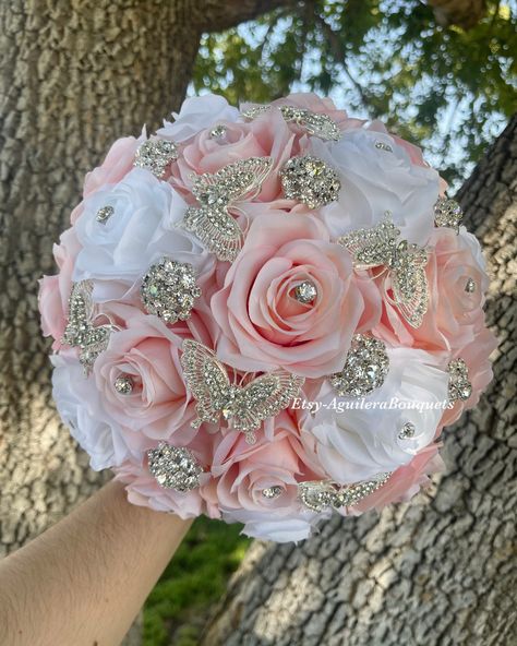 A beautiful silver brooch pink blush and ivory bouquet, for your special occasion. All our bouquets are handmade to order with high-quality roses. We can do it in different colors. Please select the color of your choice or message me the colors. *Different colors available* *Gold brooches available* * The colors of this bouquet in the picture are PINK BLUSH and CREAM rose with Silver brooches* *This bouquet is 10 inches in diameter* Please contact me with any questions! :) Pink Quinceanera Bouquet, Hello Kitty Quinceanera, Pink Quince Theme, Quince Bouquet, Rose Gold Quince, Rose Gold Quinceanera, Quinceanera Bouquet, Sweet 15 Party Ideas Quinceanera, Quinceanera Pink